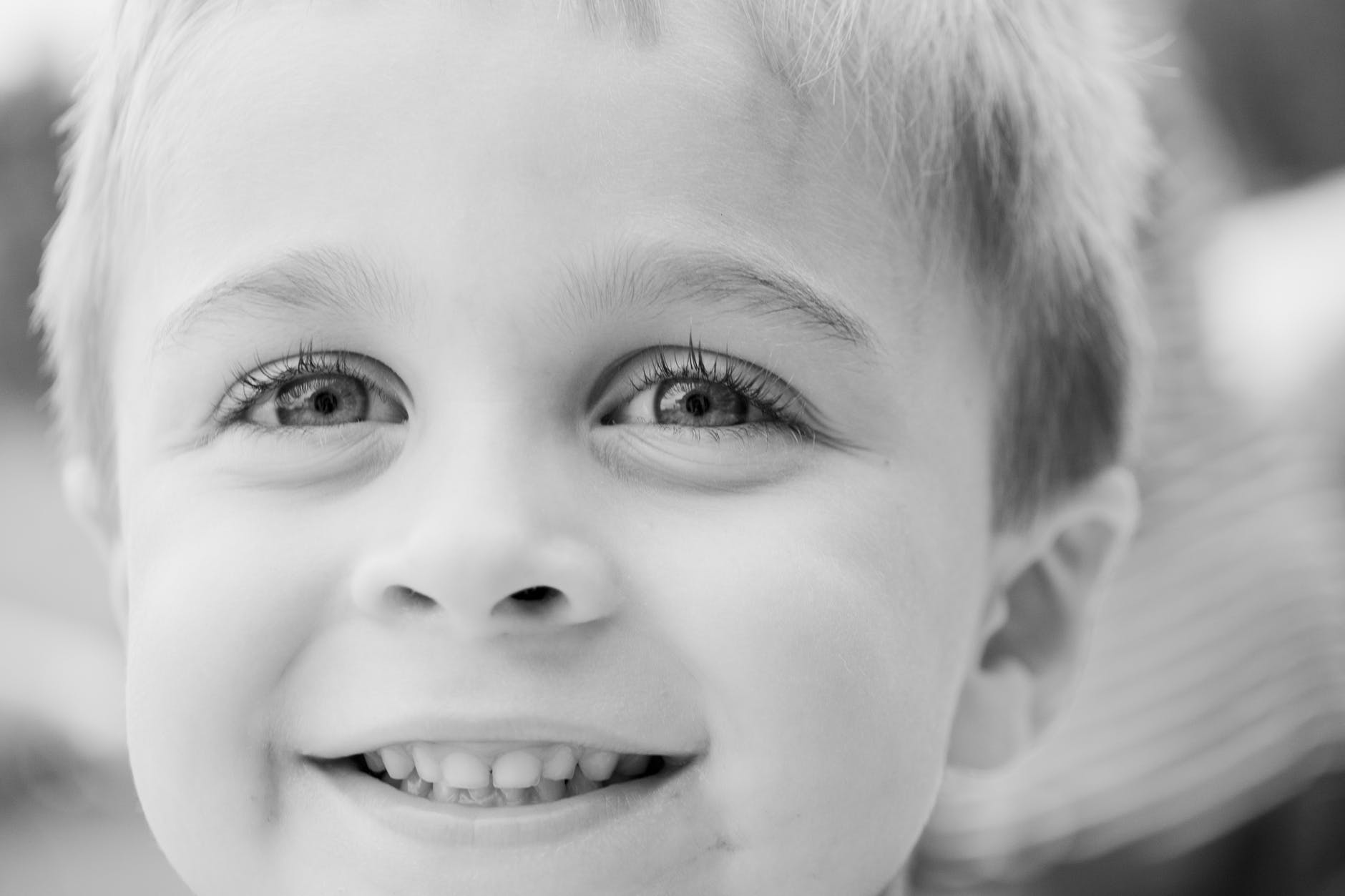 grayscale photo of toddler smiling