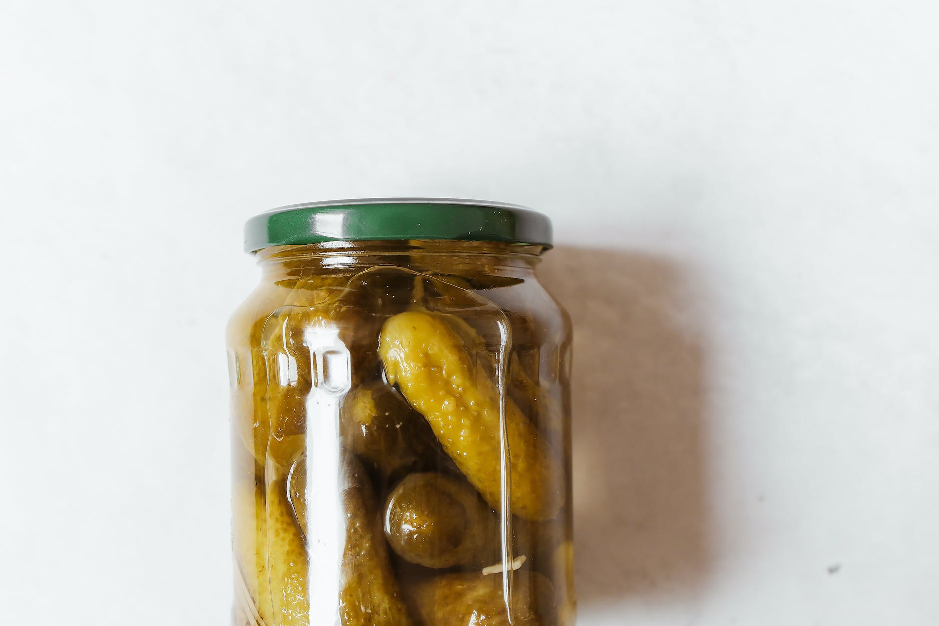 close up photo of pickles on a glass jar