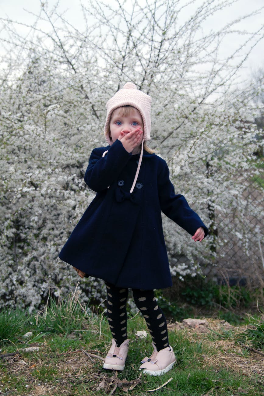 a girl in a coat and pink beanie