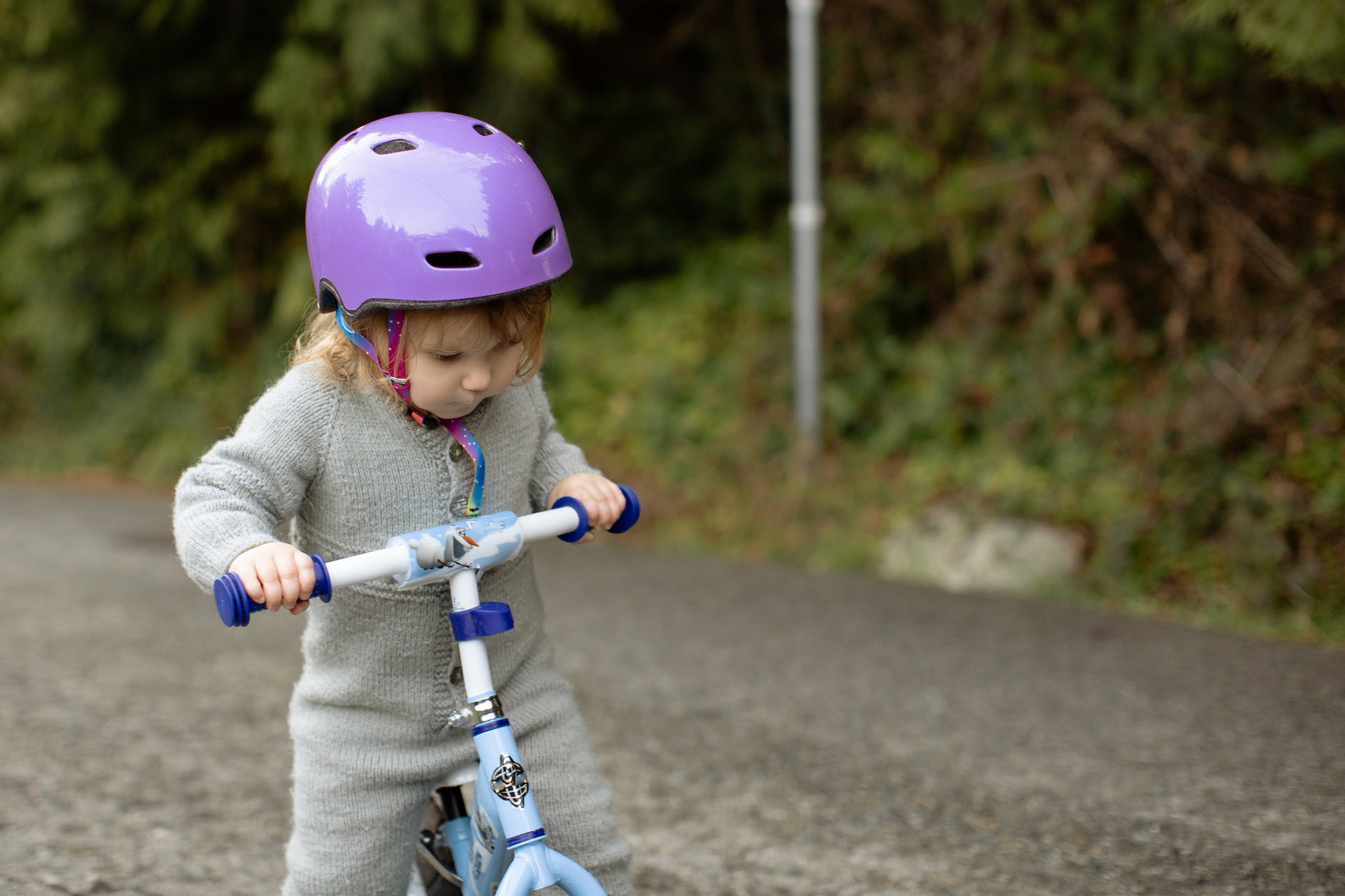 focused little cyclist girl riding runbike at countryside